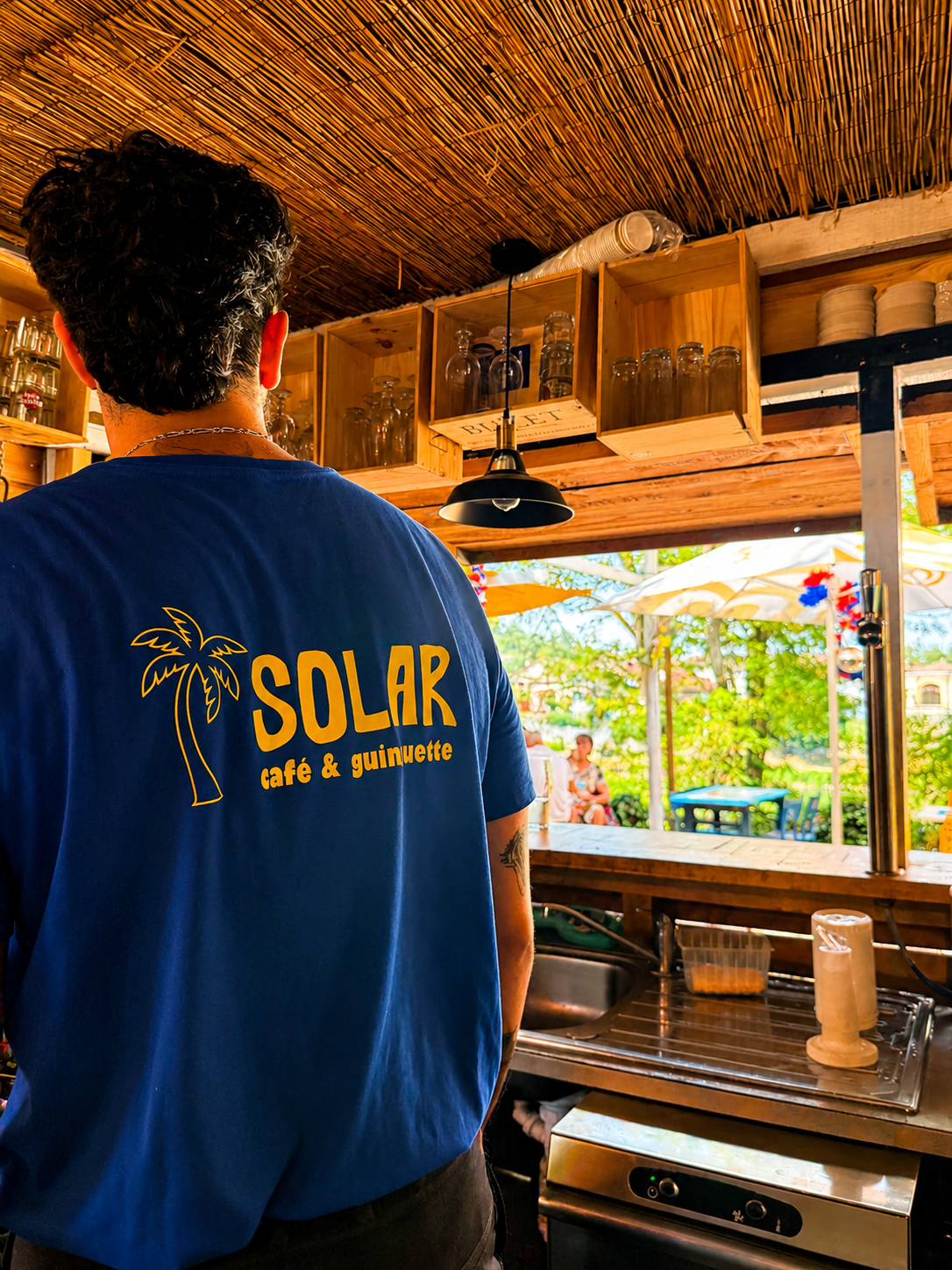 Serveur au bar avec t-shirt Solar café & guinguette